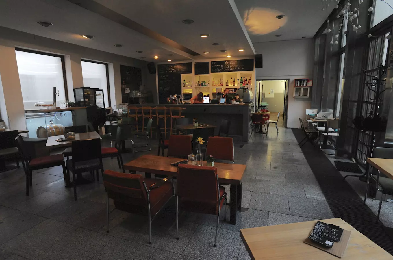 Bar Café Neustadt s křídovou tabulí, pípou a koženými židlemi ve funkcionalistickém interiéru